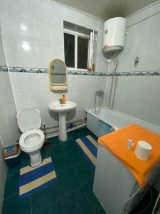 a bathroom with a white toilet and a sink at Грин сити in Balykchy