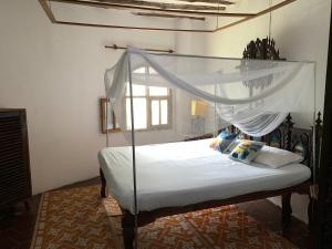 a bedroom with a bed with a canopy at The Mousa House in Malindi