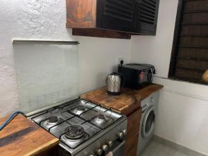 a kitchen with a stove top and a microwave at The Mousa House in Malindi +1 photo