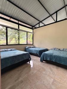 two beds in a room with windows at Finca Lantana Oficial in Villeta +12 photos