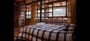 a bedroom with a checkered bed in a room with windows at Casa Qenqo in Cusco