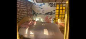 a bed in a room with a wall with graffiti at Casa Qenqo in Cusco