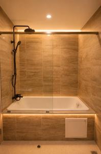 a bath tub in a bathroom with wooden walls at Punnawithi House Bangkok in Amphoe Phra Khanong