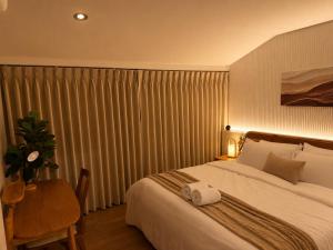 a hotel room with a bed and a table with a towel on it at Punnawithi House Bangkok in Amphoe Phra Khanong