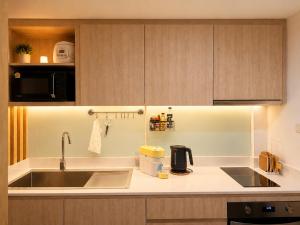 a kitchen with a sink and a microwave at Punnawithi House Bangkok in Amphoe Phra Khanong +4 photos