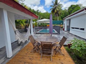 a patio with a table and chairs and a pool at Villa Fleur de Lys MAE in Morne-à-lʼEau
