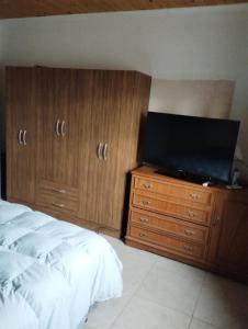 a bedroom with a bed and a television on a dresser at Casa quinta Los Teros in Sánchez de Loria