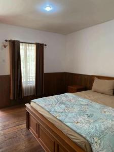 a bedroom with a large bed and a window at Katra Sembalun in Sembalun Lawang +3 photos