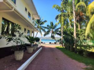 a house with palm trees on the side of a road at Chalets Anse Possession in Baie Sainte Anne