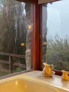 two yellow vases sitting on a window sill at Huellas de Berna in Villa Berna +1 photo