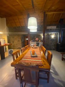 a dining room table with chairs and a light fixture at Huellas de Berna in Villa Berna