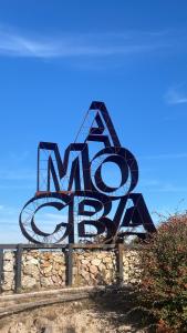 a large metal sculpture of the word art on a stone wall at Huellas de Berna in Villa Berna