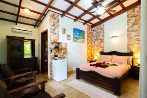 a bedroom with a bed and a chair in a room at Casa Caribbean Coconut in Cahuita +81 photos