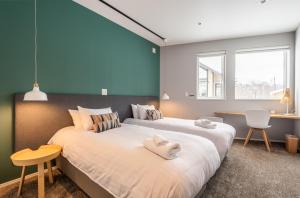 a bedroom with a large bed with towels on it at The Orchards Niseko in Kutchan +26 photos
