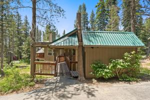 a tiny house in the woods with a green roof at Stargazing Retreat in Tamarack in Big Creek
