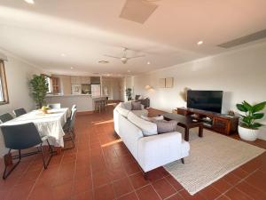 a living room with a white couch and a table at The Balcony at Airlie in Airlie Beach