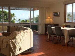 a living room with a couch and a table with chairs at The Balcony at Airlie in Airlie Beach