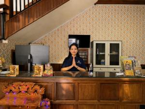 a woman is sitting at a counter with her hands in front at Champs Elysees Boutique Hotel in Phumĭ Réach Born (2) +38 photos
