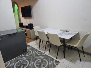 a dining room with a white table and chairs at A nice one bedroom apartment in Mills Center