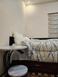 a bed with a table next to a bed with a bedskirts at A nice one bedroom apartment in Mills Center