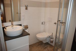 ein weißes Bad mit einem Waschbecken und einem WC in der Unterkunft Hotel zur Linde in Hanau am Main
