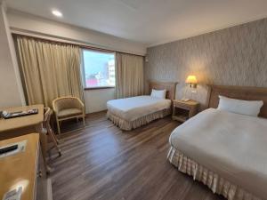 a hotel room with two beds and a window at Cambridge Tainan Hotel in Tainan +50 photos
