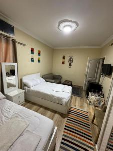 a bedroom with two beds and a couch at Akhnaton pyramids inn in Cairo