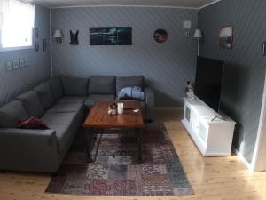 a living room with a couch and a coffee table at Komfortabel overnatting på veien mot Nordkapp in Kolvik