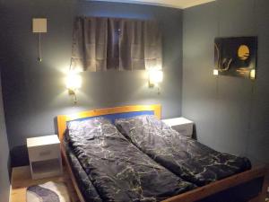 a bedroom with a bed with two night stands at Komfortabel overnatting på veien mot Nordkapp in Kolvik