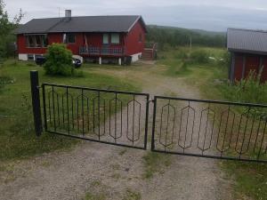 a gate in front of a red house at Komfortabel overnatting på veien mot Nordkapp in Kolvik