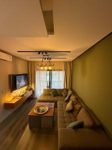 a living room with a couch and a tv at Golf Heights Resort Nabq Bay Sharm Elsheakh in Sharm El Sheikh