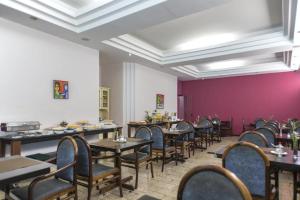 a dining room with tables and chairs and purple walls at Apartamento Saint Moritz flat service in São Bernardo do Campo +31 photos