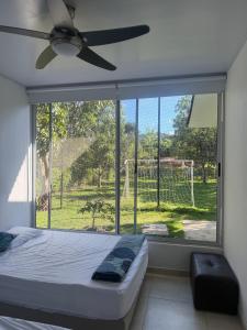 a bedroom with a bed and a large window at Finca para estrenar in Anapoima
