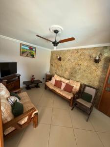 a living room with a couch and a tv at Chácara 3 quartos com piscina e churrasqueira in Itatiba