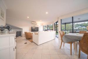 a kitchen and living room with a table and chairs at Avoca Beachside Retreat in Avoca Beach +44 photos