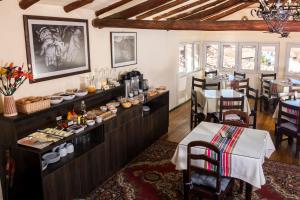 a restaurant with a buffet of food and a dining room at Hostal Corihuasi in Cusco