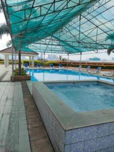 a large swimming pool with chairs and a canopy at Monte Carlo Lounge Two in Manila +9 photos