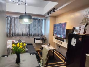 a living room with a table and a tv at Monte Carlo Lounge Two in Manila