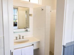 a white bathroom with a sink and a mirror at Squid's Ink Motel in Belmont +42 photos