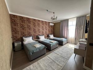 a living room with two beds and a couch at Zere Motel in Türkistan +12 photos