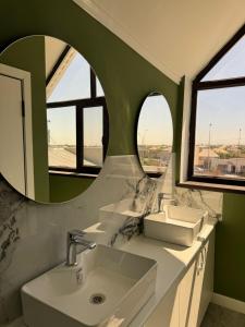 a bathroom with two sinks and a mirror at Zere Motel in Türkistan