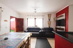 a living room with a couch and a table at Sinuca, churrasqueira e fogueira a 300 metros do mar in Itanhaém