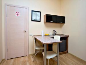 a small kitchen with a table and chairs in a room at Sunday Apart Hotel in Kyiv