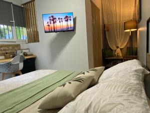 a bedroom with a bed with a television on the wall at L'Isménia, L'écrin Zen in Le Gosier