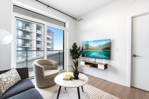 a living room with a couch and a table and a window at Stylish Skyview Condo in Kitchener Downtown in Kitchener