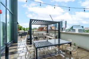 a patio with a table and chairs on a roof at Stylish Skyview Condo in Kitchener Downtown in Kitchener