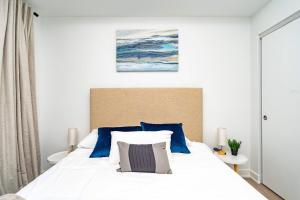 a bedroom with a large white bed with blue pillows at Stylish Skyview Condo in Kitchener Downtown in Kitchener +38 photos