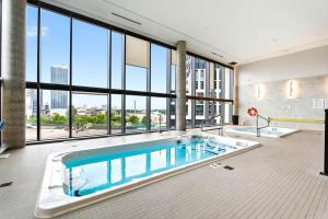 a large swimming pool in a building with a large window at Stylish Skyview Condo in Kitchener Downtown in Kitchener