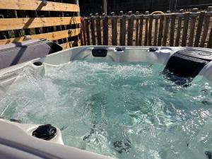 a bath tub filled with water in front of a fence at Black Stone Family Garden Villa in Yaoqiaoyu