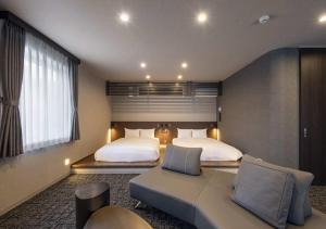 a bedroom with two beds and a couch in it at グランマリーナホテル in Osaka +26 photos